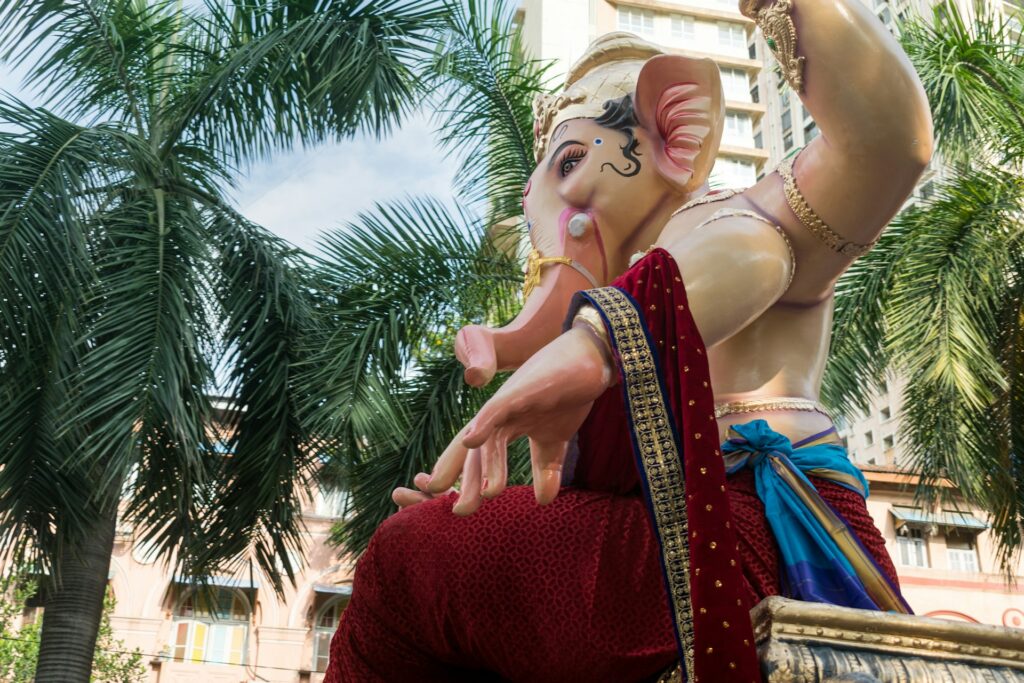 A Ganesha idol in red clothing during the arrival procession