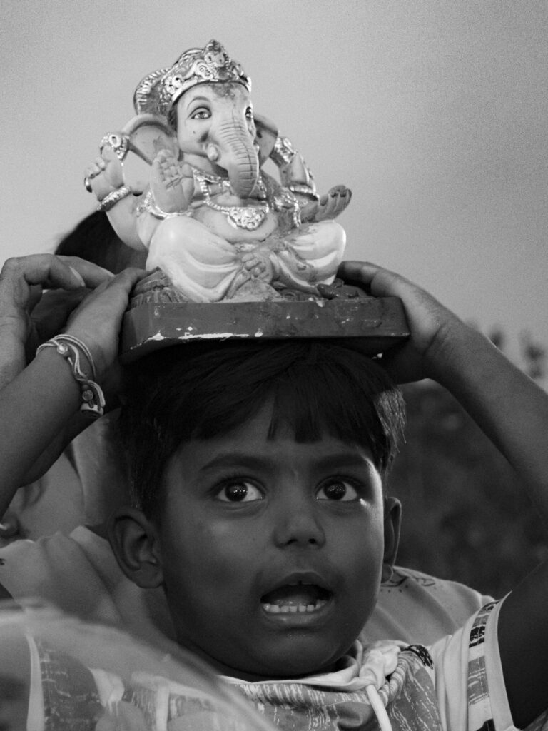 A boy carrying a small Ganesha idol during the festival