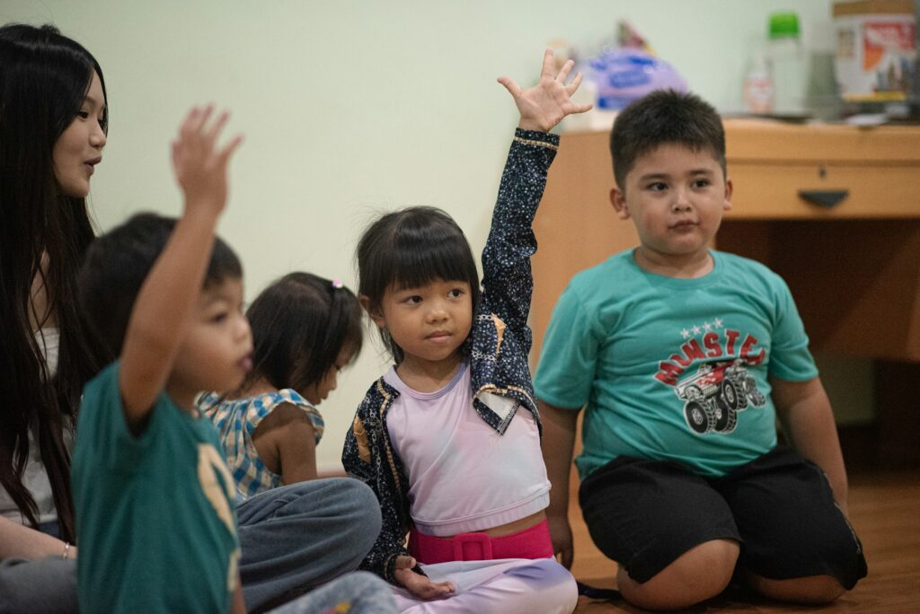 Children raising their hands in a classroom