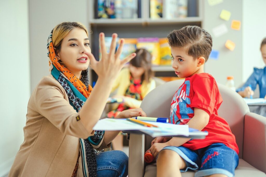 A teacher showing a child numbers with her fingers