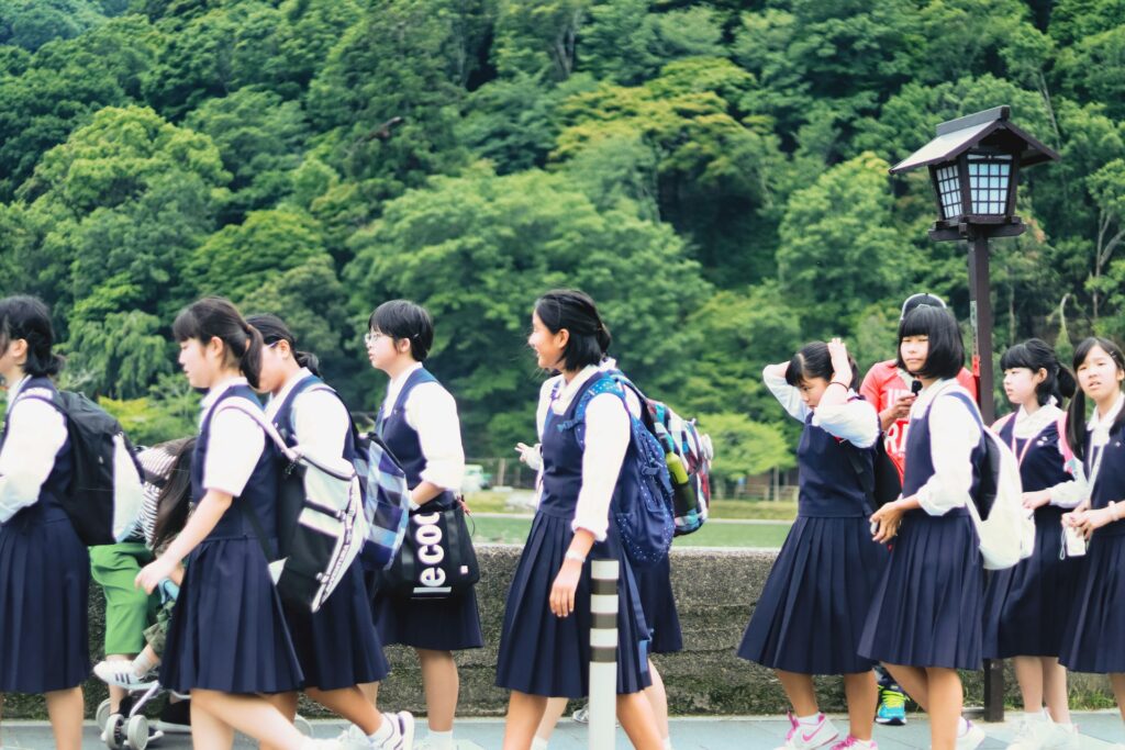 Students in school uniform on a green field outing